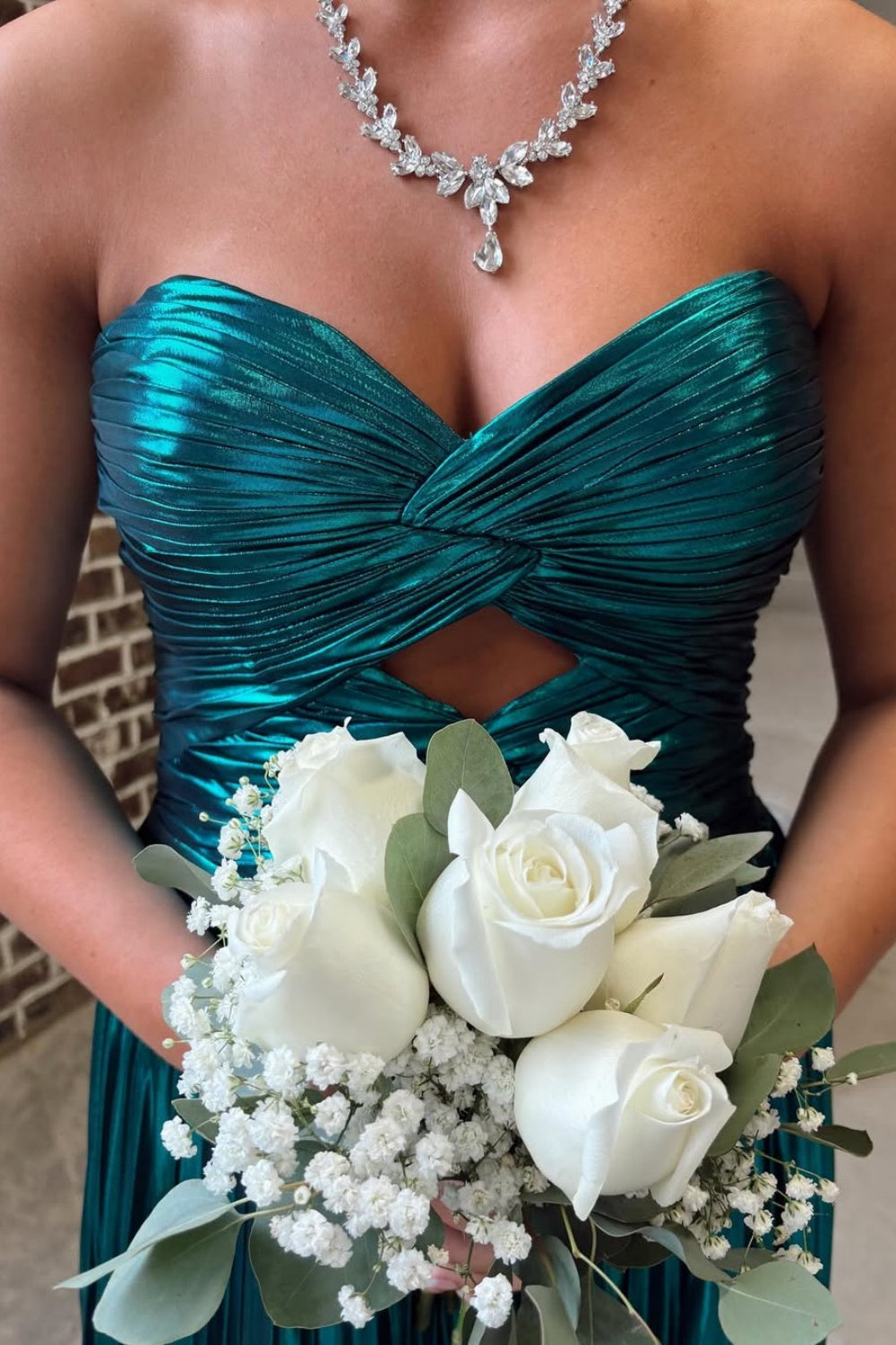 Metallic green strapless pleated A-line prom dress with twist keyhole detail.