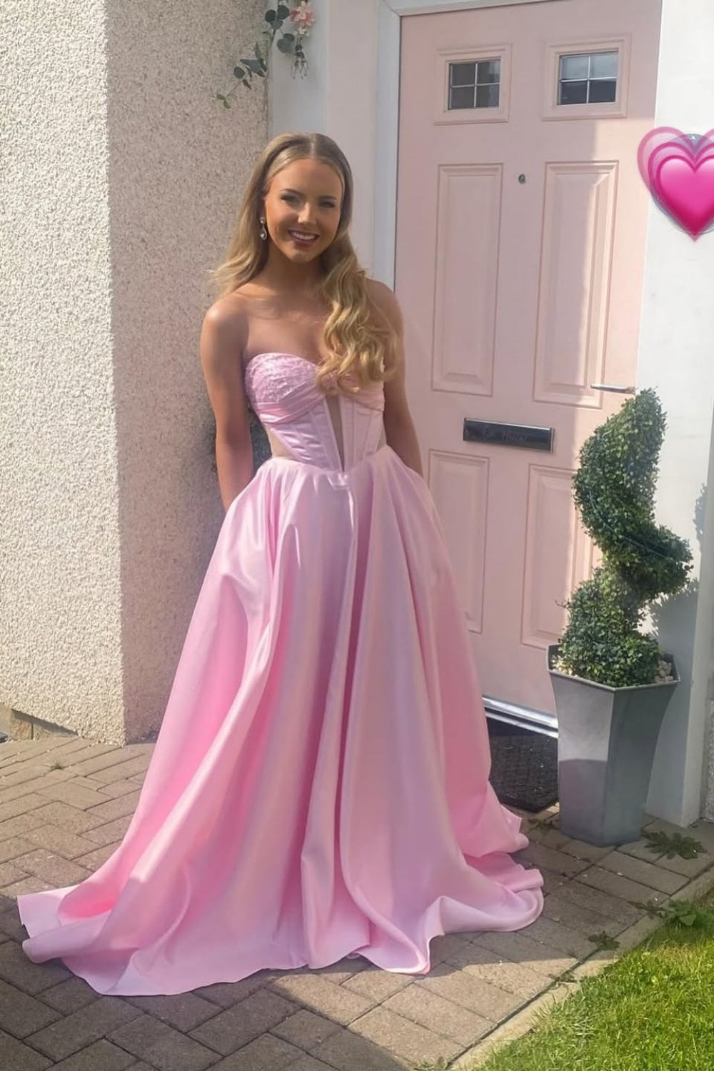 Light pink A-line satin prom gown featuring a sweetheart neckline, beaded bodice, and side cut-out details.