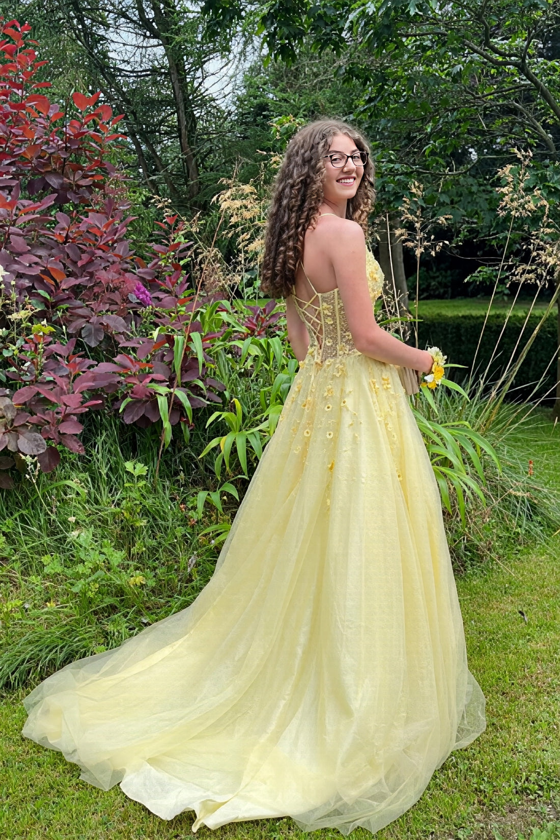 Yellow A-line tulle prom dress featuring vibrant 3D-flower appliques and delicate spaghetti straps.
