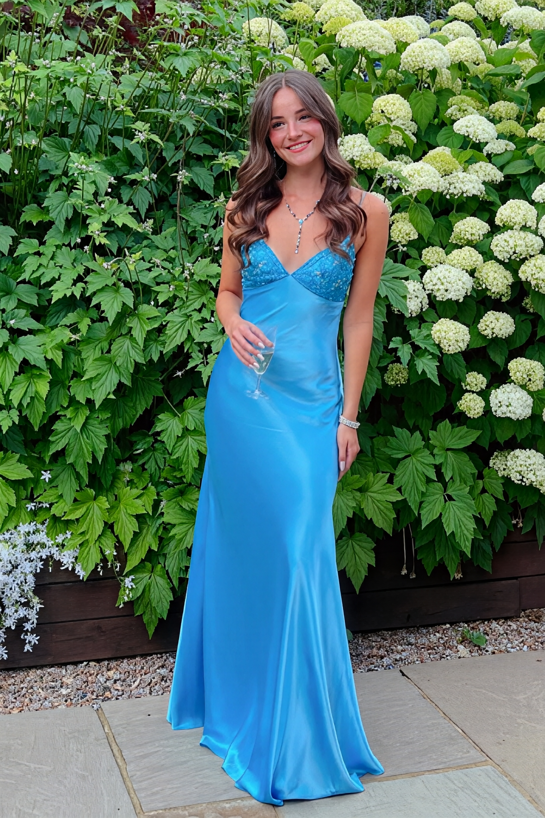 Blue mermaid satin prom dress featuring shimmering beaded spaghetti straps and a sleek, fitted silhouette.