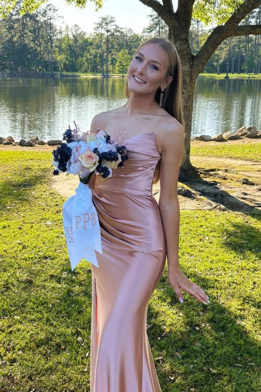 Blush pink long prom dress featuring a strapless neckline, a sophisticated ruched fitted bodice, and a sleek floor-length silhouette.