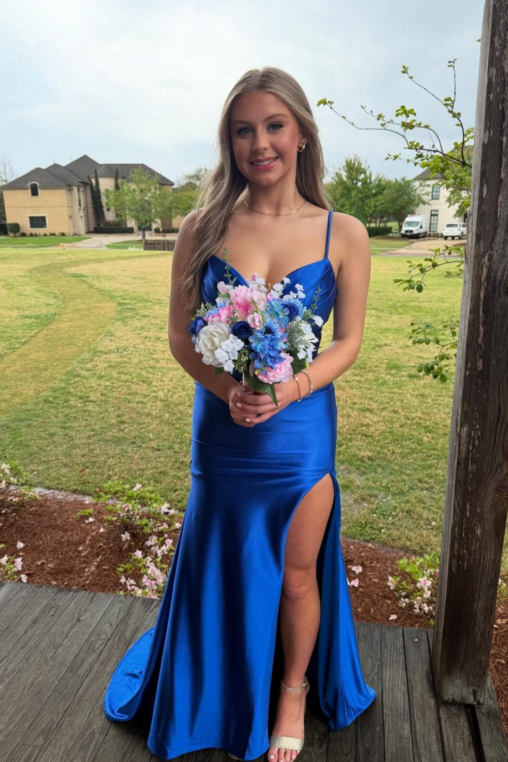 Royal blue mermaid prom dress with spaghetti straps, side slit, and ruched details.