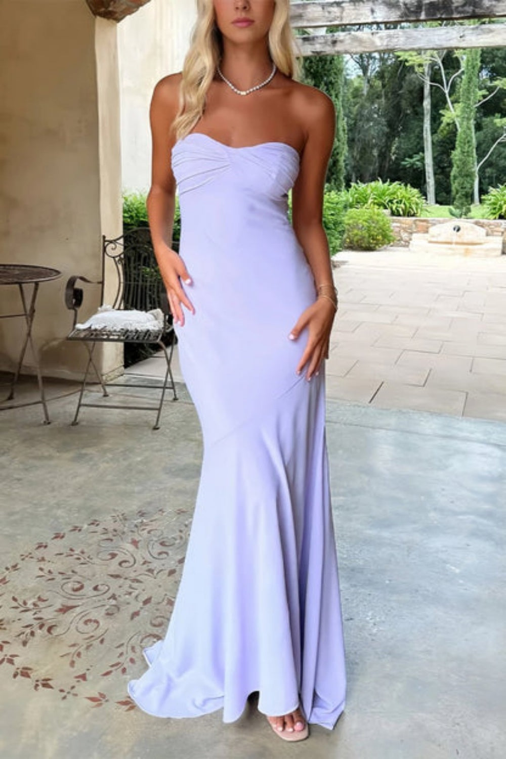 Lavender mermaid prom dress with a strapless neckline, ruched bodice, and adjustable lace-up back.