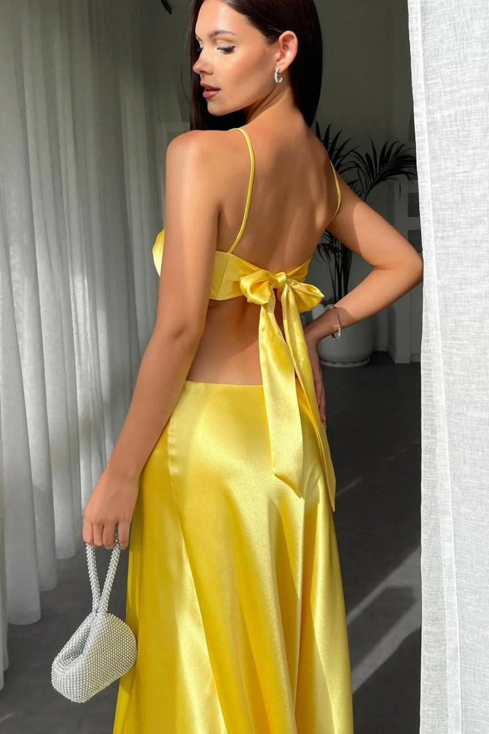 mermaid prom dress with spaghetti straps, waist cut-outs, and a stylish bow design.