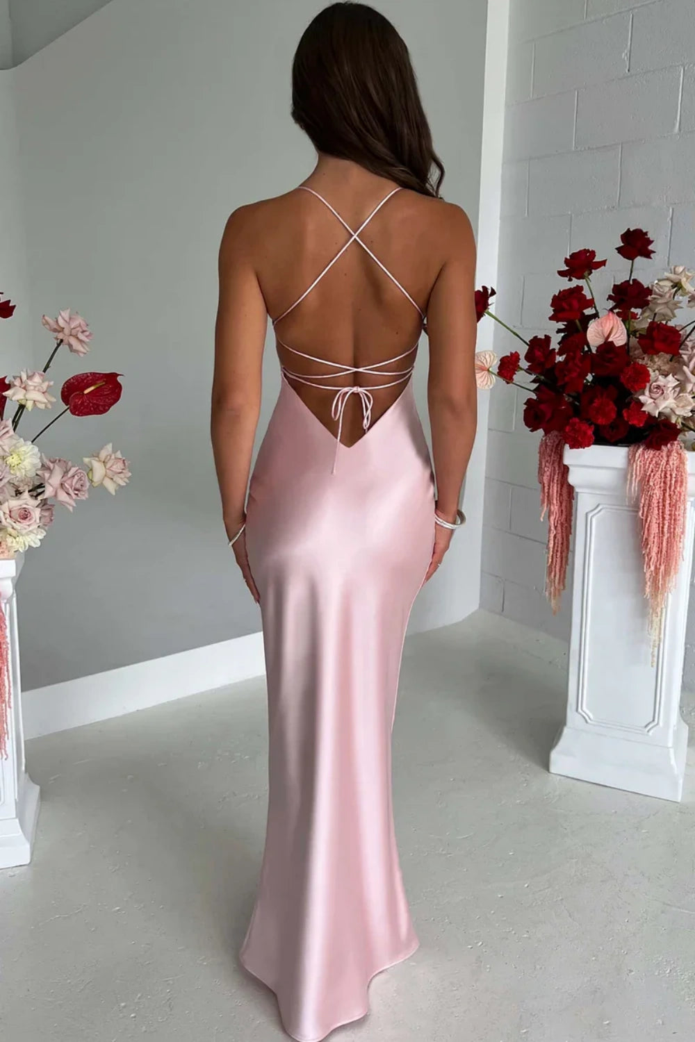 Fitted long pink formal prom dress with delicate spaghetti straps and a criss-cross lace-up back.