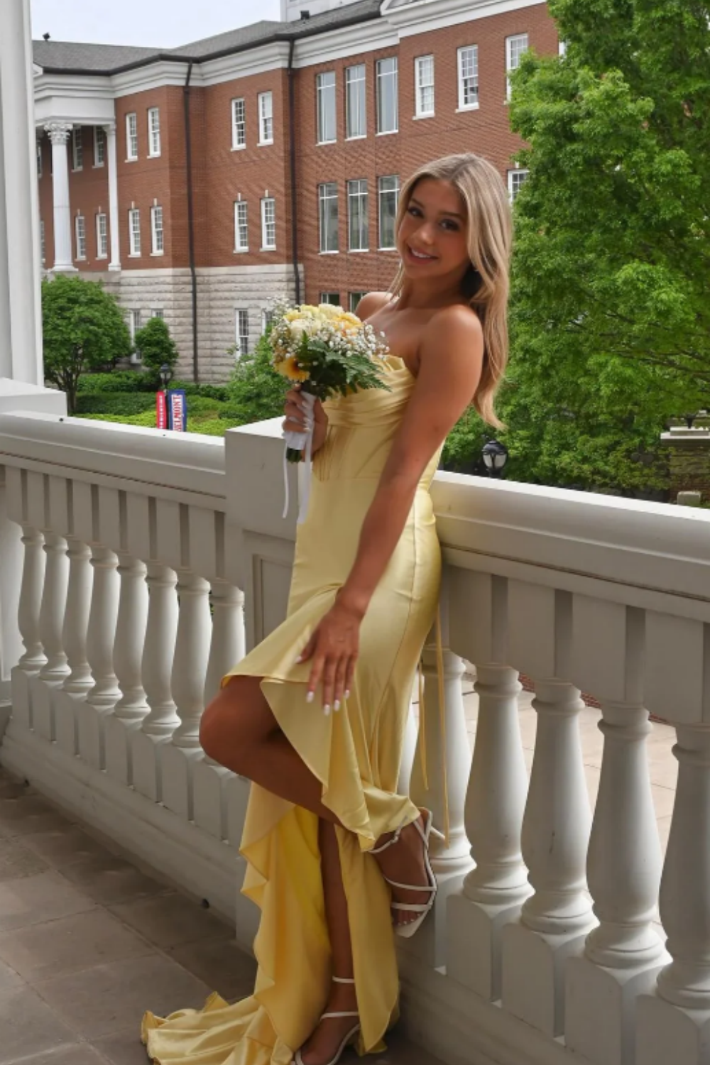 Yellow satin A-line prom dress featuring a trendy cowl neckline, ruched waist detailing, and a high side leg slit.