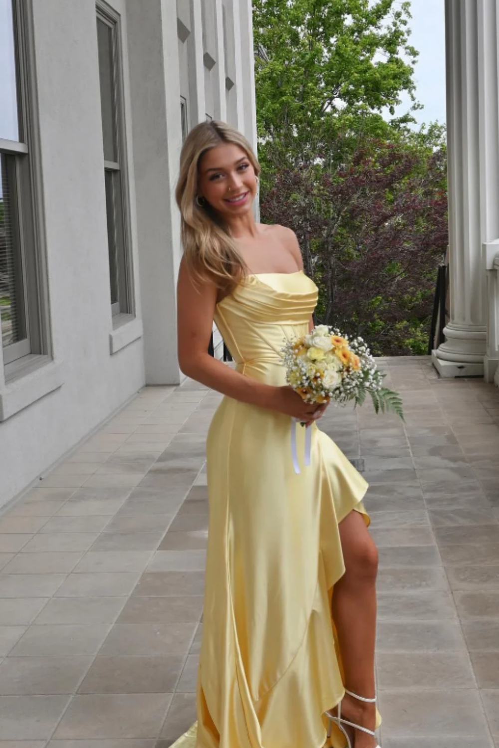 Yellow satin A-line prom dress featuring a trendy cowl neckline, ruched waist detailing, and a high side leg slit.