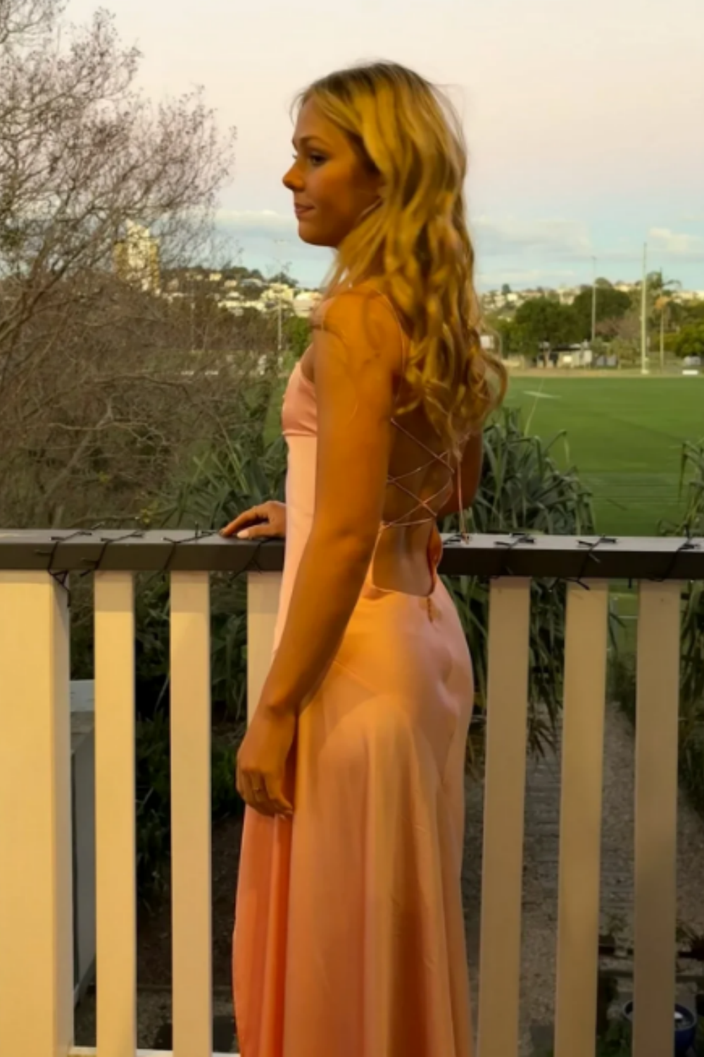 Pink long formal mermaid dress featuring double spaghetti straps, a ruched bodice, and a high side leg slit.