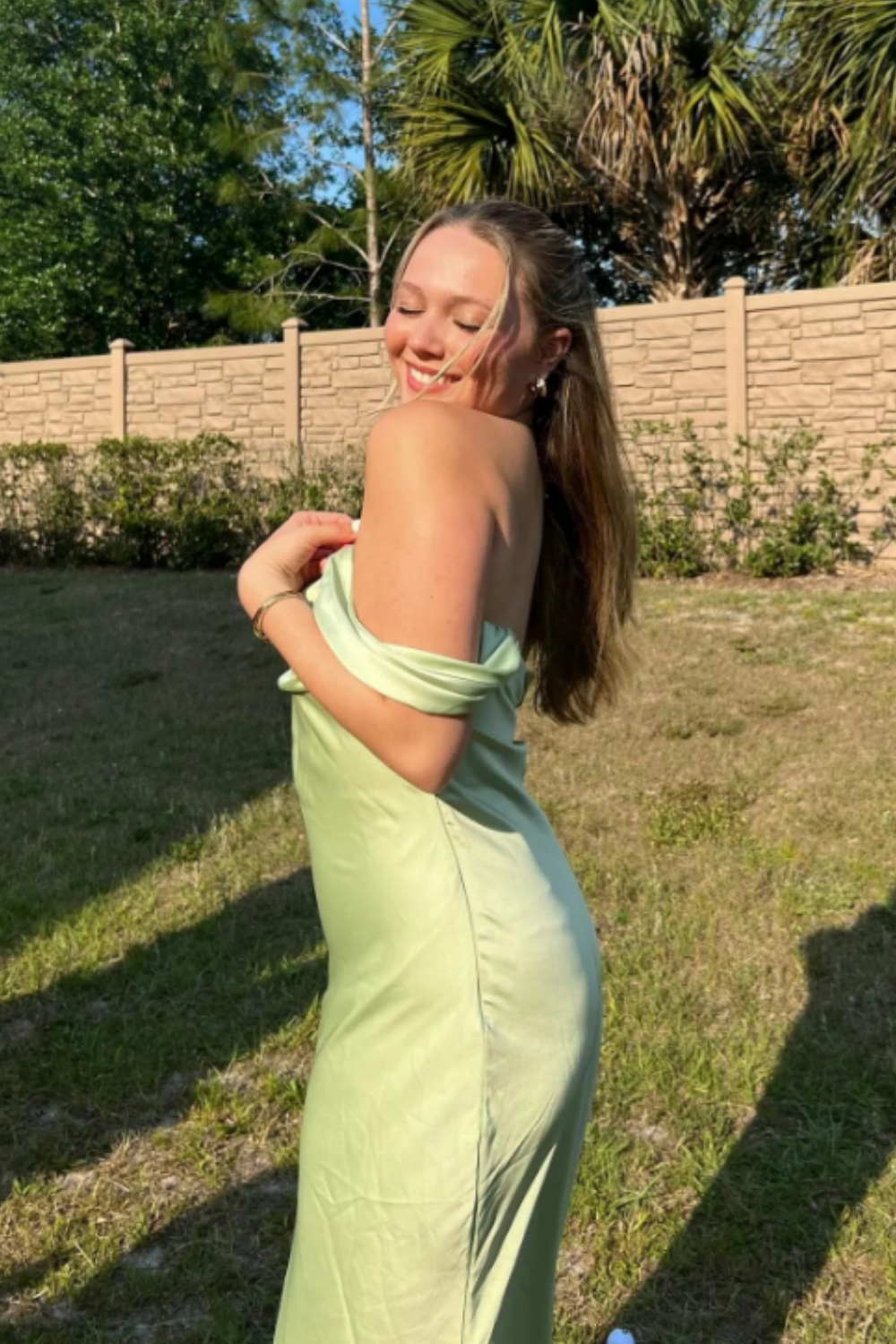 long formal gown featuring an off-the-shoulder neckline, fitted mermaid silhouette, and elegant ruched detailing.