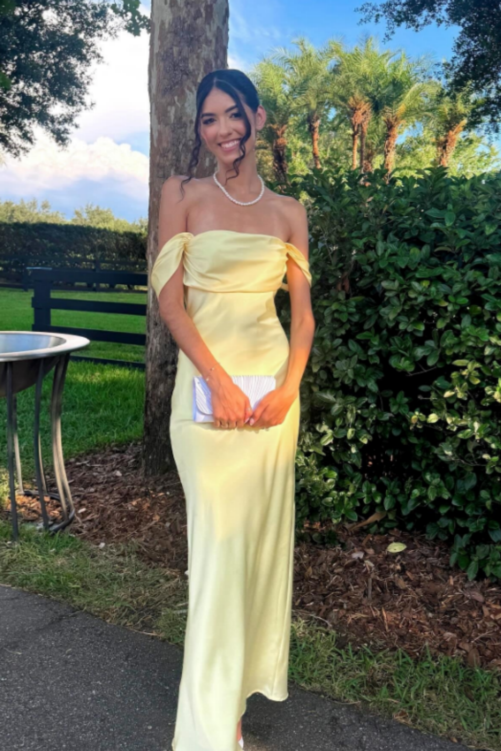 long formal gown featuring an off-the-shoulder neckline, fitted mermaid silhouette, and elegant ruched detailing.