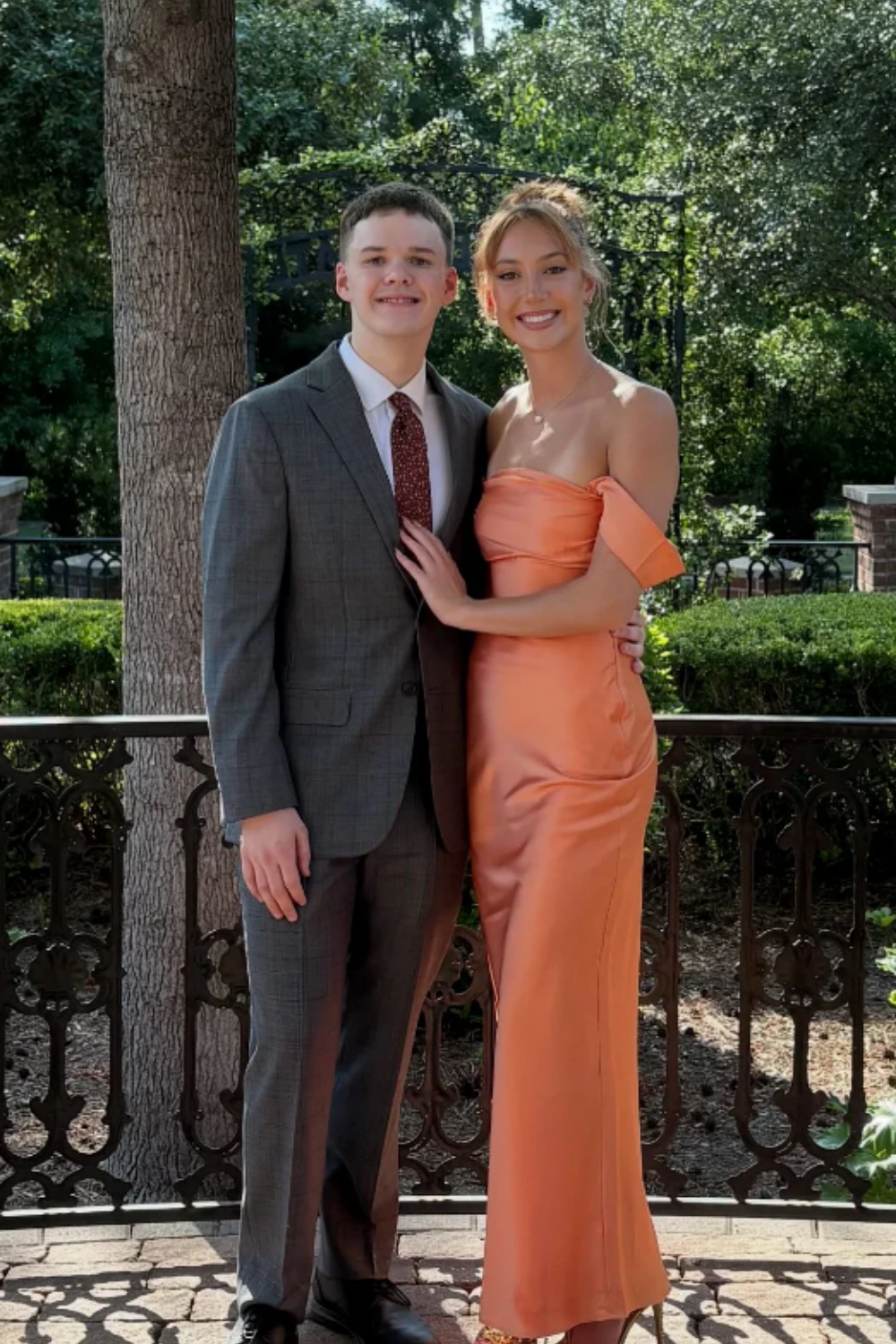 long formal gown featuring an off-the-shoulder neckline, fitted mermaid silhouette, and elegant ruched detailing.