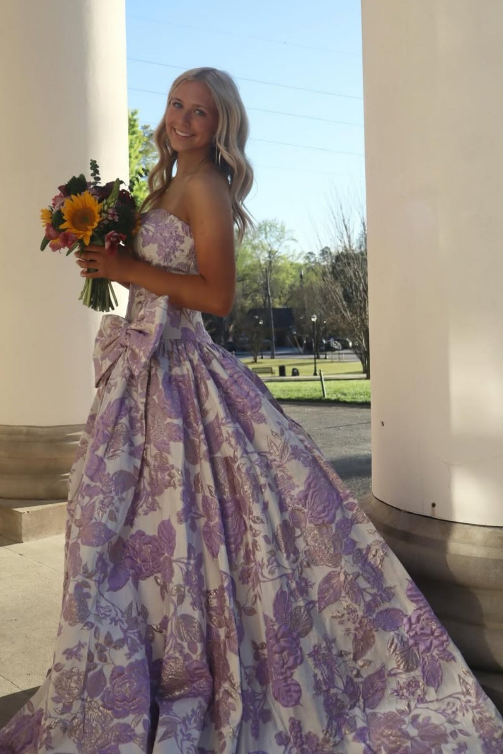 Strapless floral print A-line dress with a bow detail.