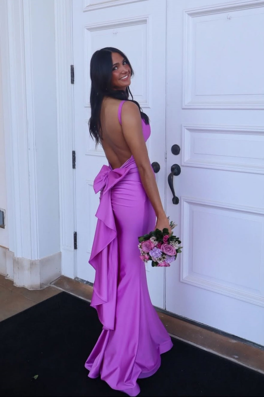 Purple plunging V-neck mermaid dress with open back and large bow.