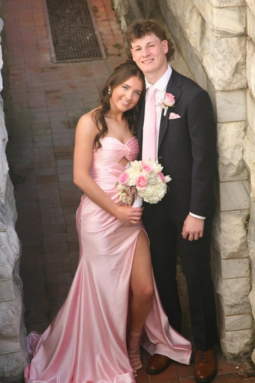 Strapless pink ruched mermaid gown with keyhole cutout and side slit.