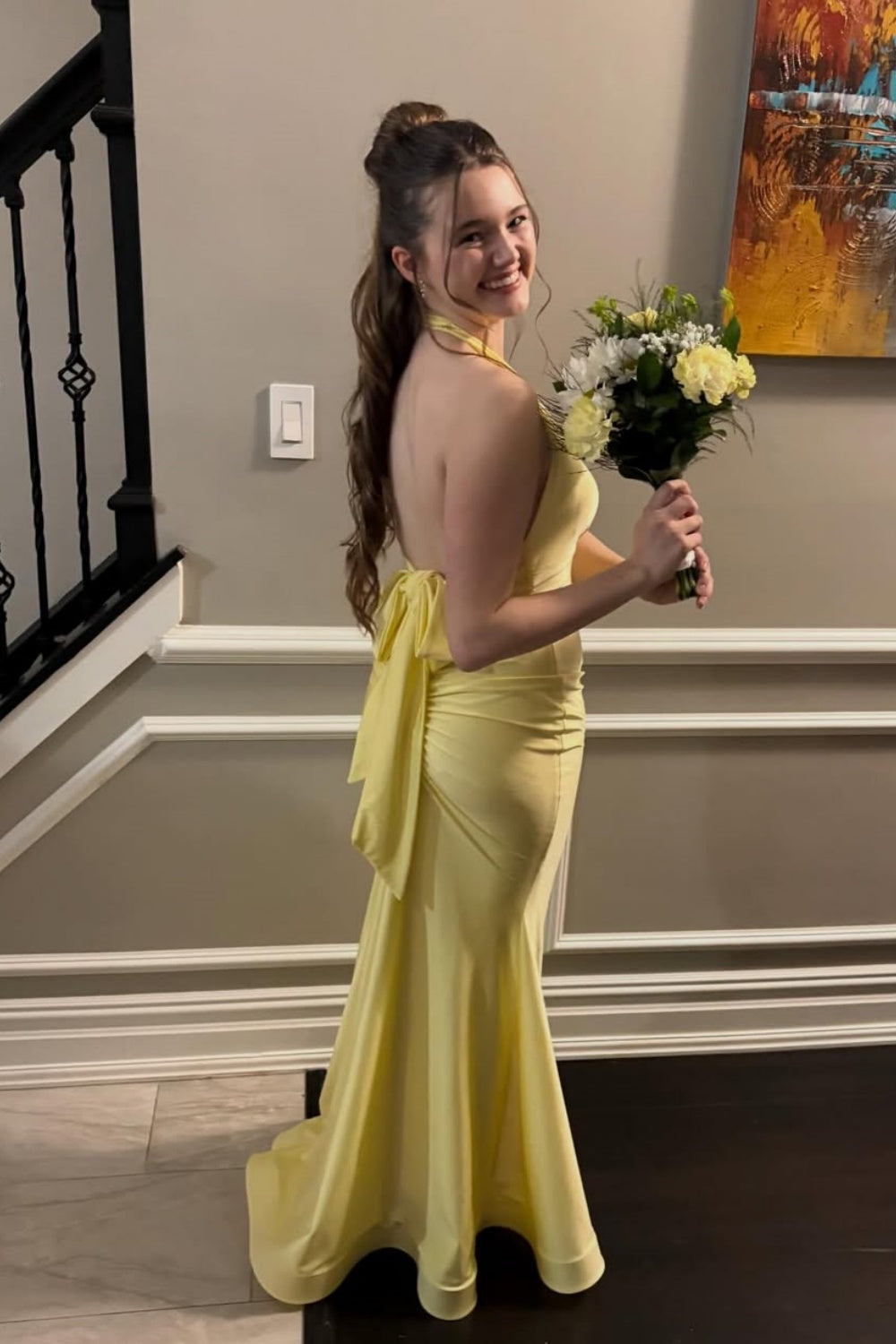 Yellow halter mermaid dress with ruched bodice and open back.