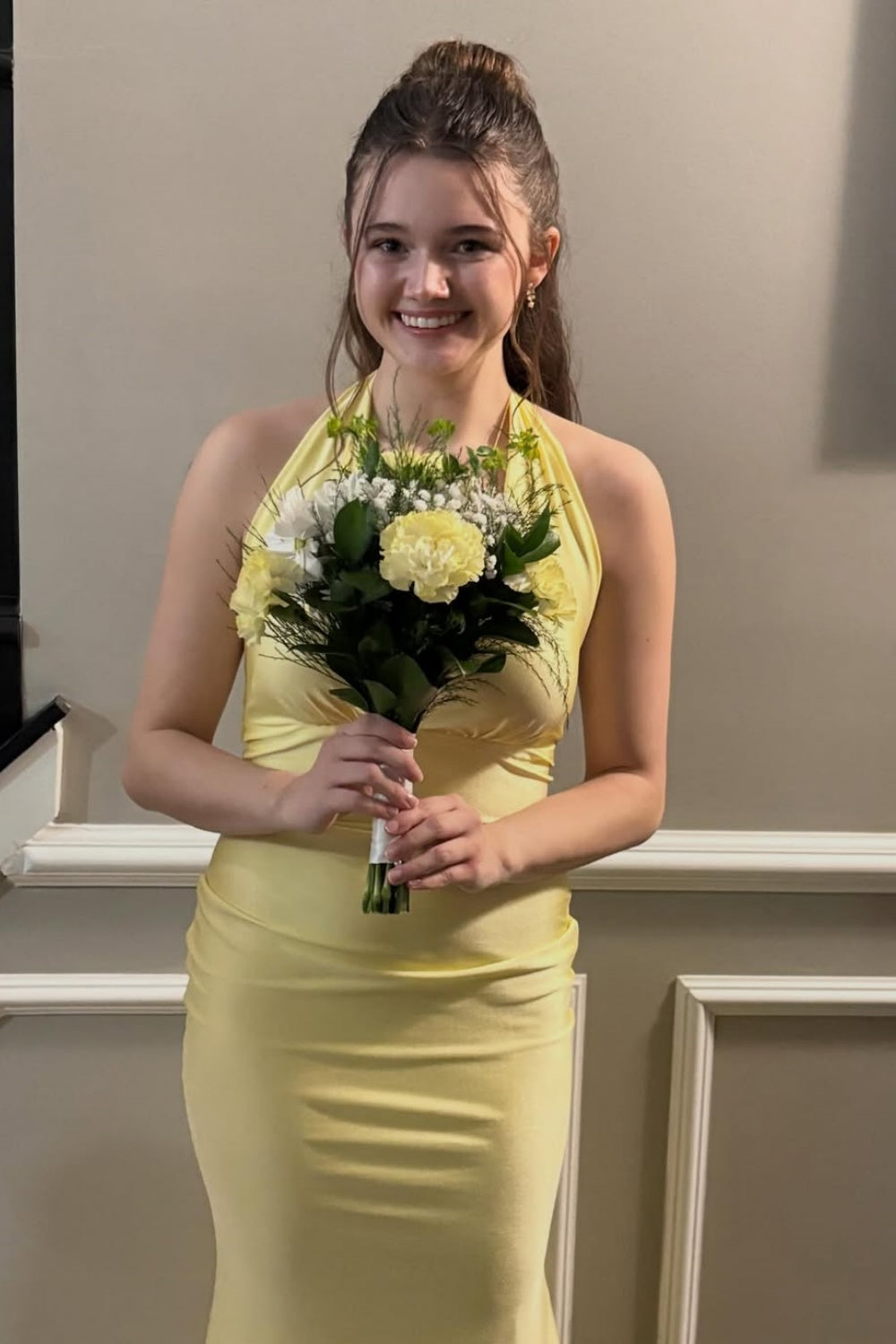 Yellow halter mermaid dress with ruched bodice and open back.