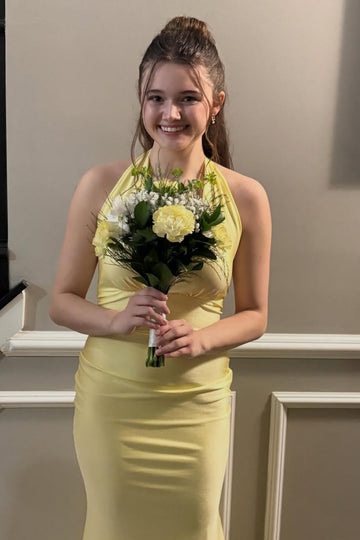 Yellow halter mermaid dress with ruched bodice and open back.