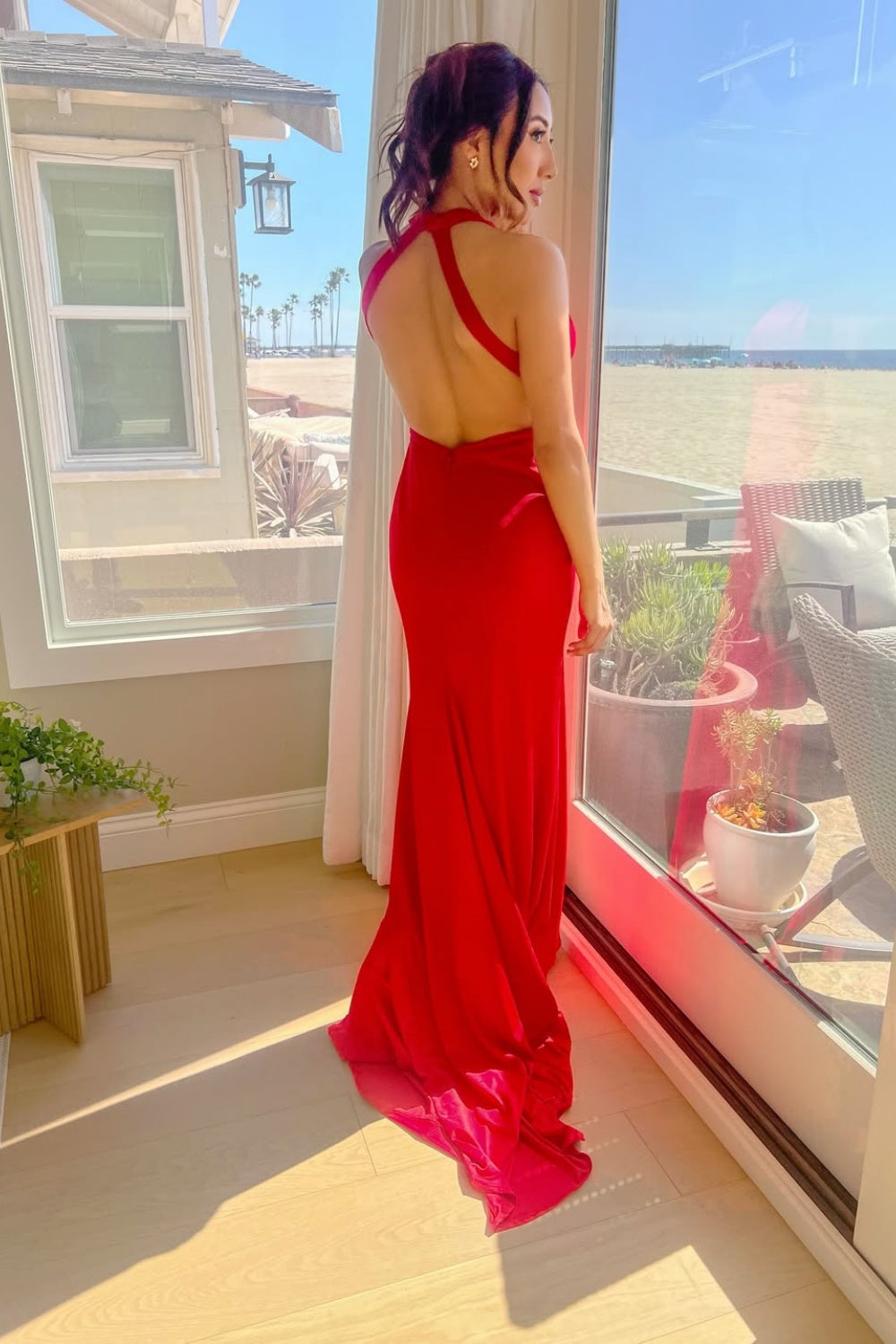 Red halter fitted satin formal dress with an open back.