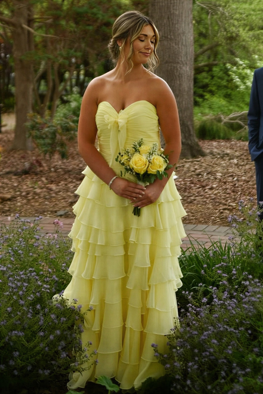 Sunny yellow strapless chiffon A-line prom dress with tiered layers, ruching, and bow detail.