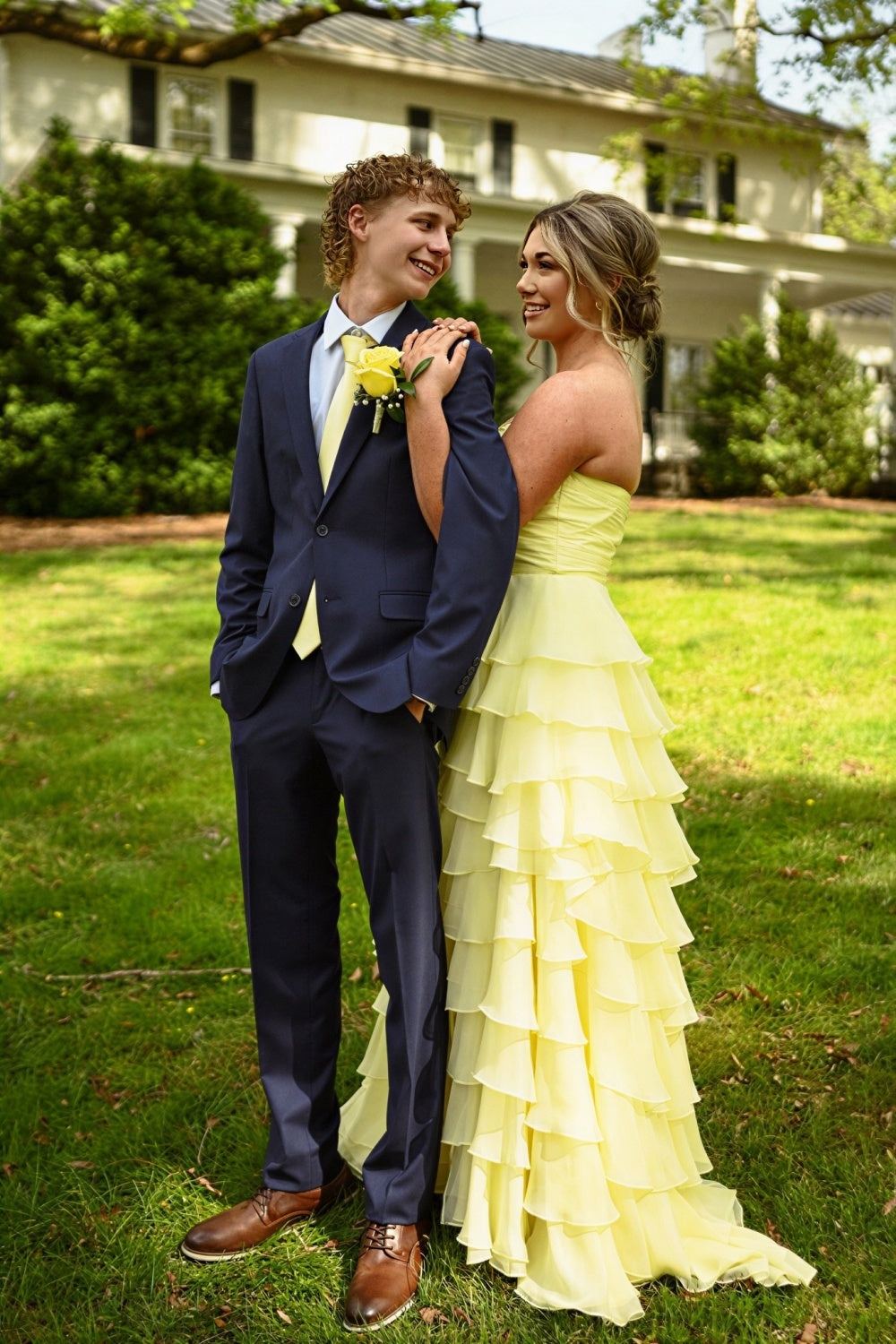 Sunny yellow strapless chiffon A-line prom dress with tiered layers, ruching, and bow detail.
