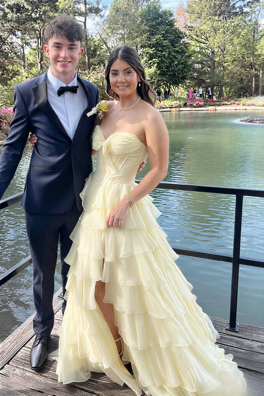 Chiffon corset yellow A-line tiered prom dress with side slit and bow.