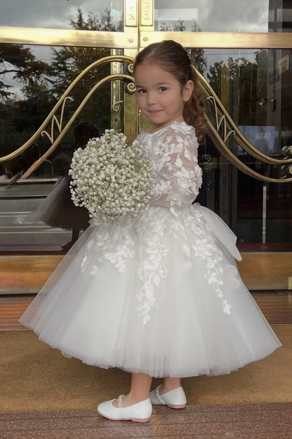 White A-line tulle flower girl dress with illusion neckline and floral appliques.