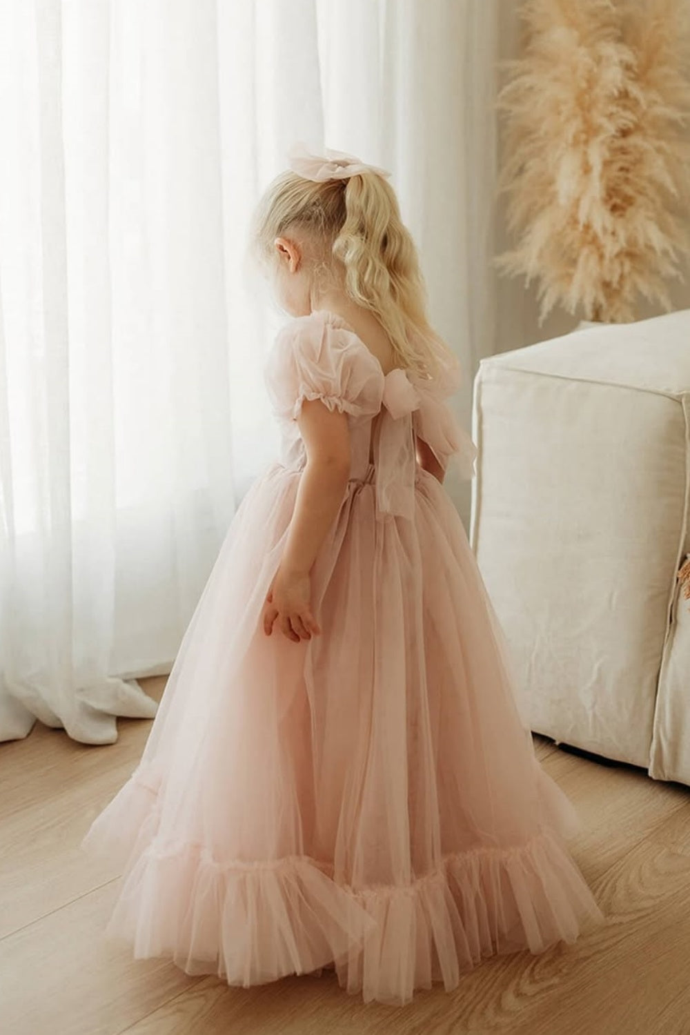 Pink A-line tulle flower girl dress with cap sleeves and back bow.