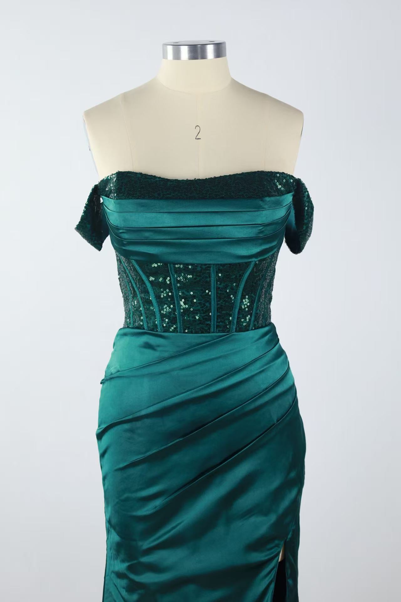 Off-the-shoulder green lace gown with side slit and lace-up back.