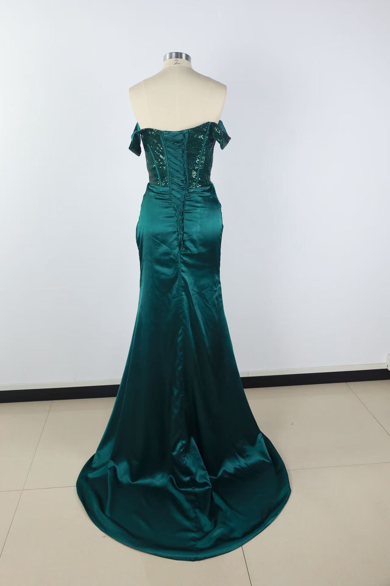 Off-the-shoulder green lace gown with side slit and lace-up back.